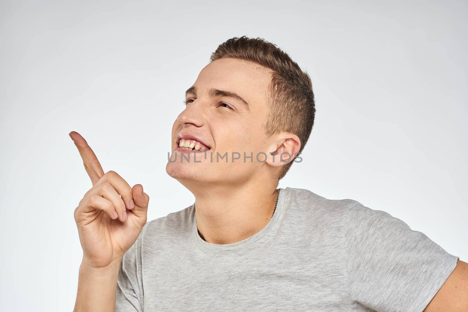 Cheerful emotional man gray t-shirt gesturing with hands studio lifestyle by SHOTPRIME