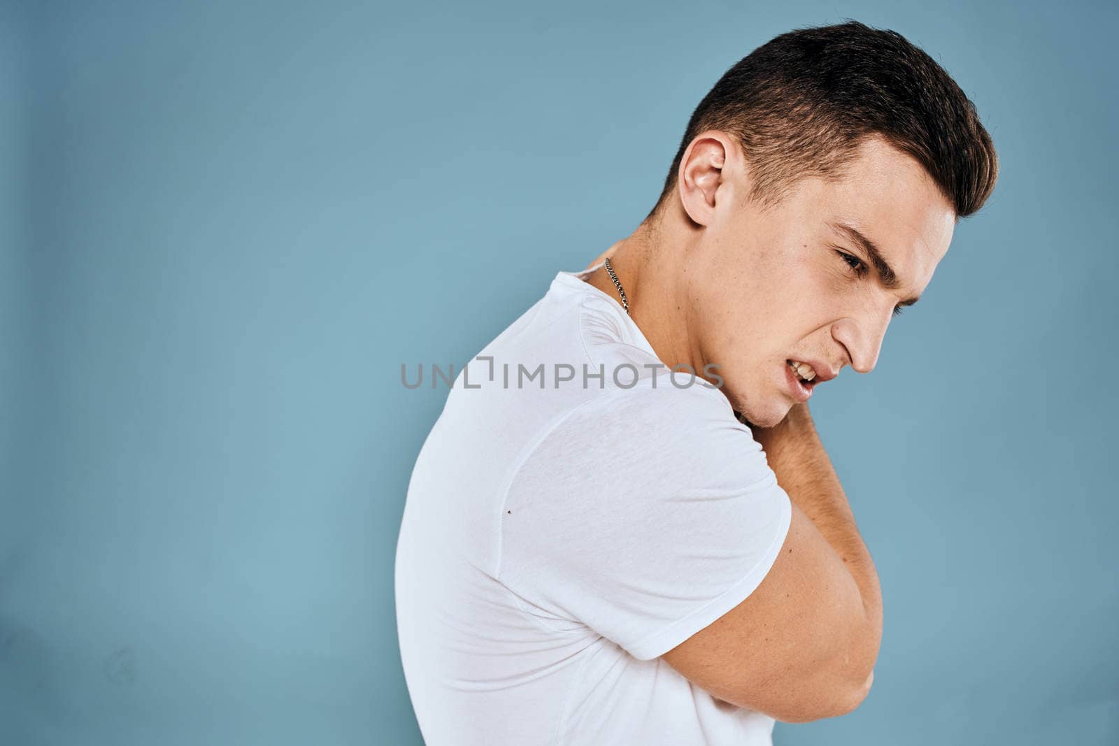 emotional displeased man cropped view white t-shirt blue background by SHOTPRIME