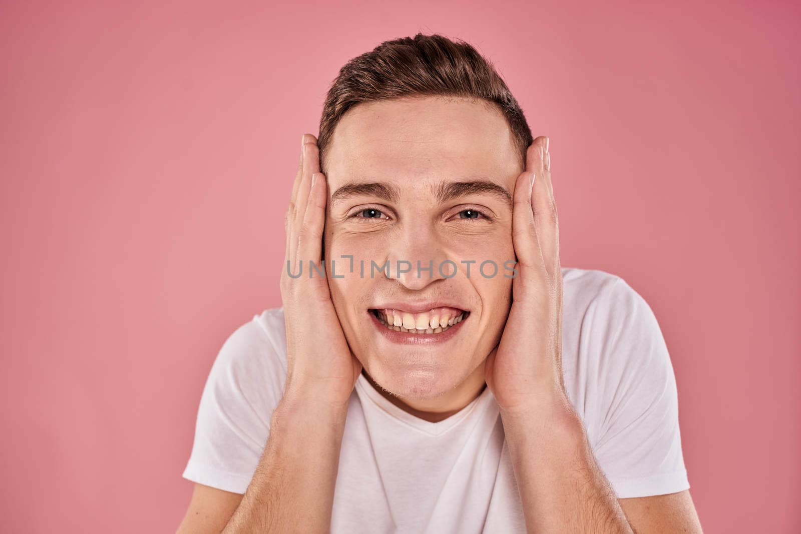cheerful man in white t-shirt smile emotions close-up pink background studio by SHOTPRIME
