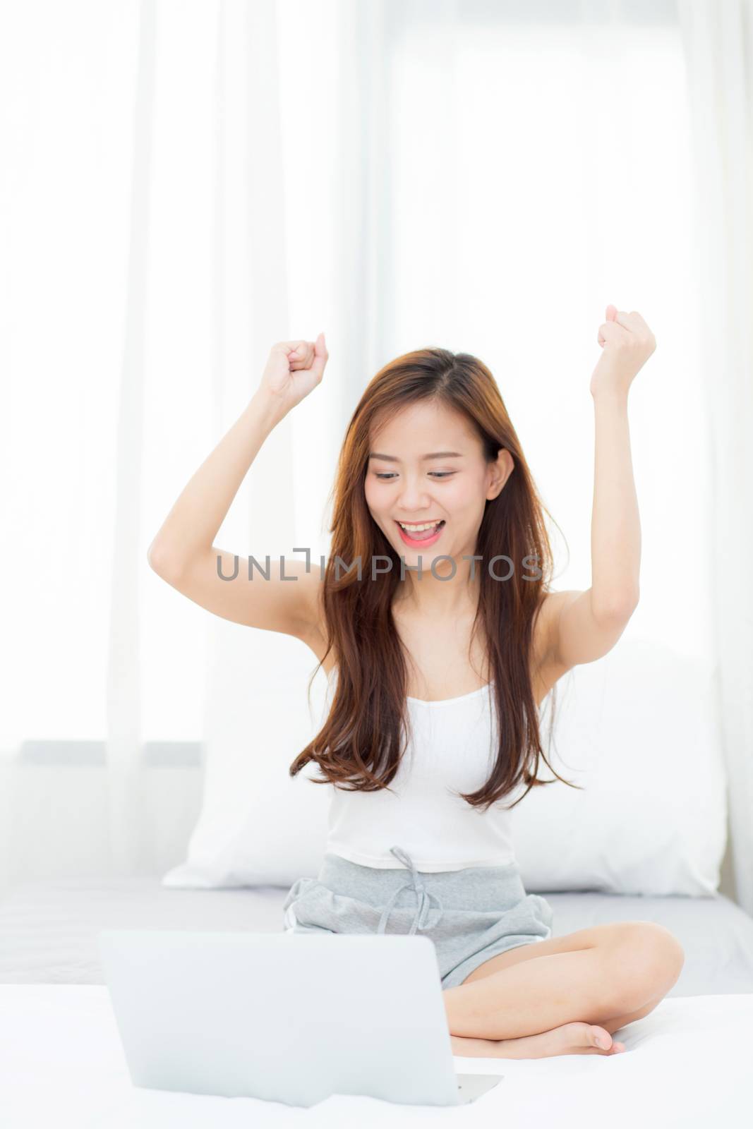 Beautiful happiness young asian woman using laptop work with success on bed in the home, girl and notebook shopping online with glad, communication concept.