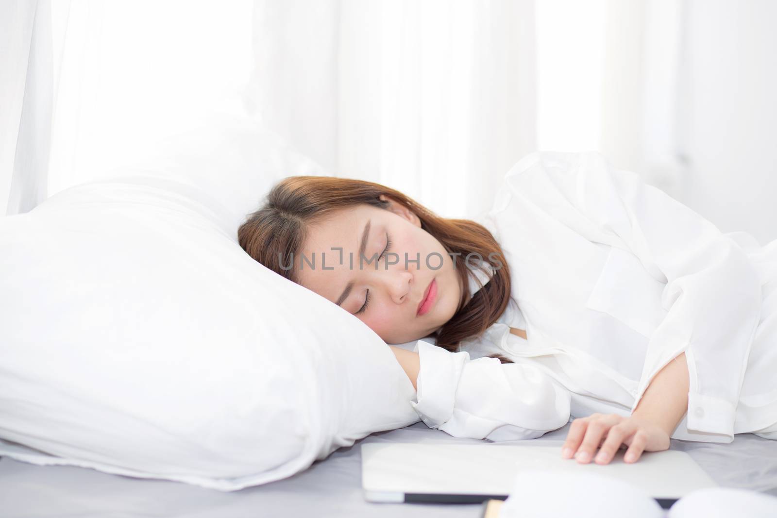 Beautiful young asian woman with laptop lying down in bedroom, girl tired sleep with computer notebook, resting and healthcare concept. 