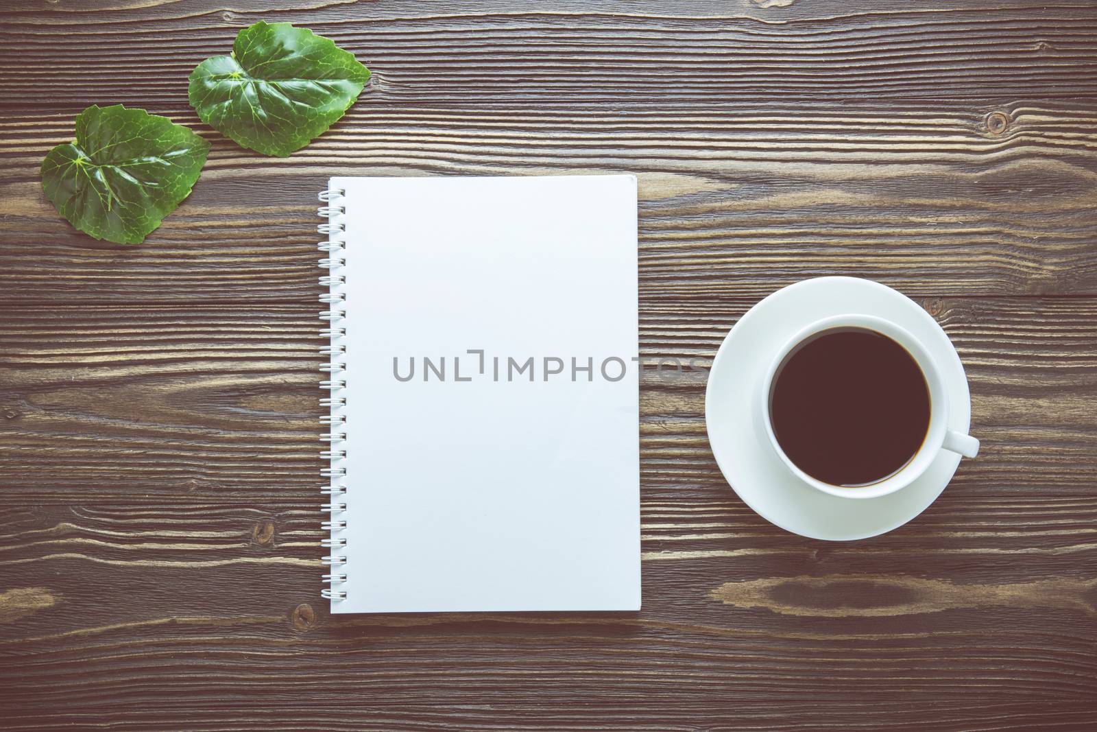 Bouquet of flower and empty diary notebook and a cup of coffee on rustic wooden table with copy space, mockup template with flower and note, top view, vintage retro style.