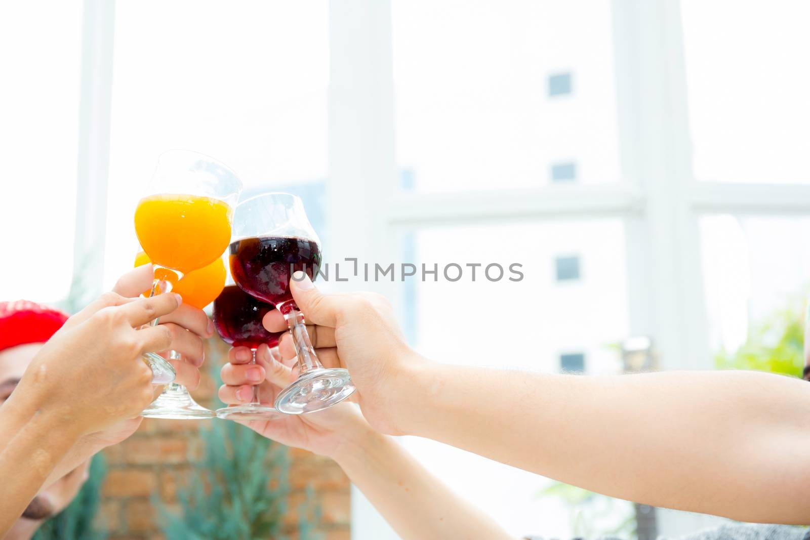 Asian group people drinking at party outdoor. group of friends cocktails in hand with glasses.close up on hand holding beverage.