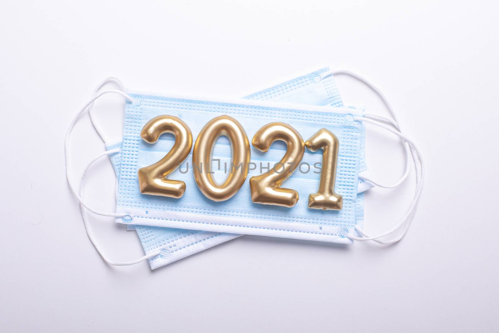Gold numbers 2021 with face mask on white background. Happy new pandemic year