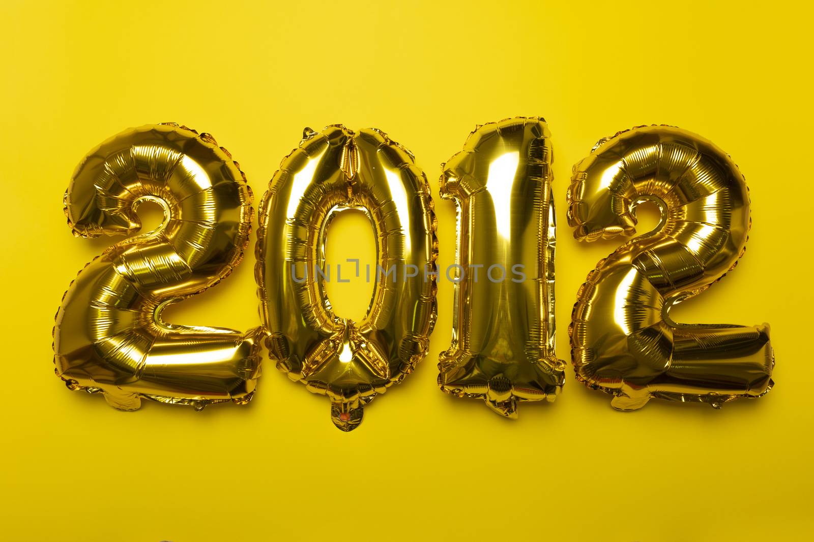 2021 new year concept from golden foil balloon on yellow backgro by adamr