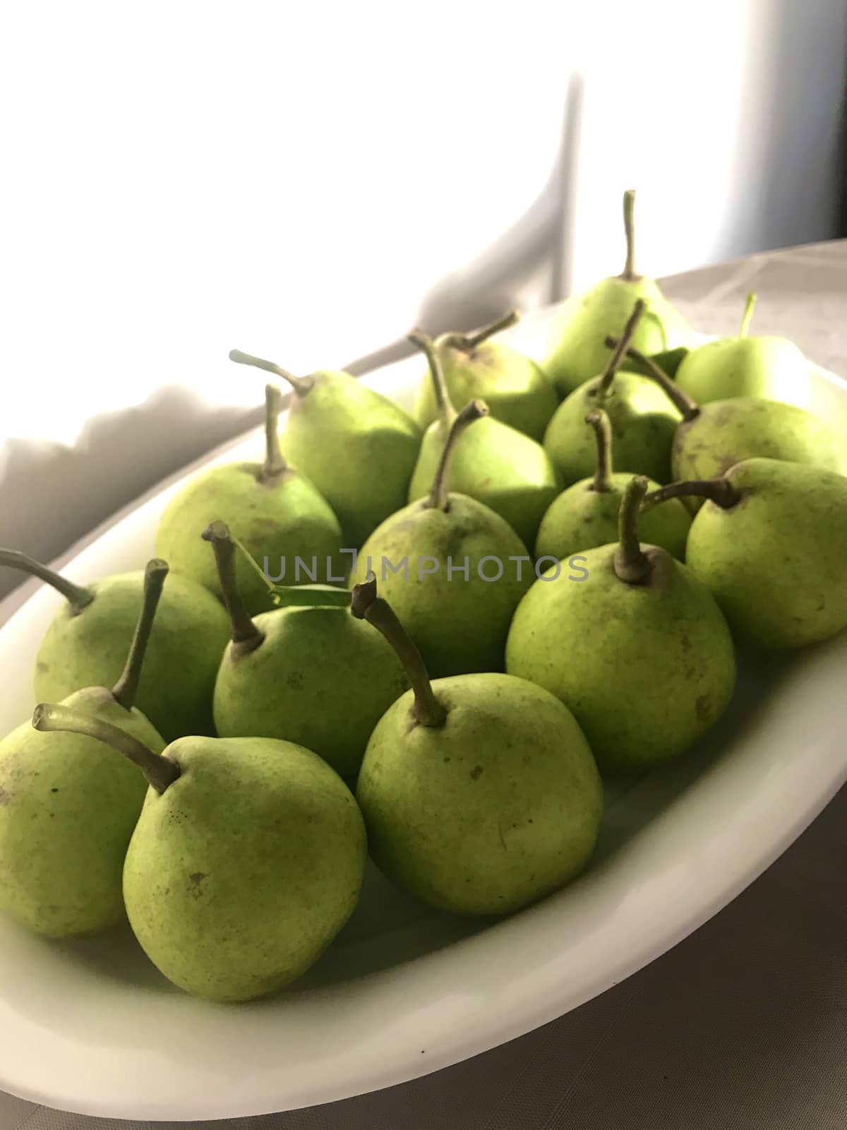 Green pears on a white plate