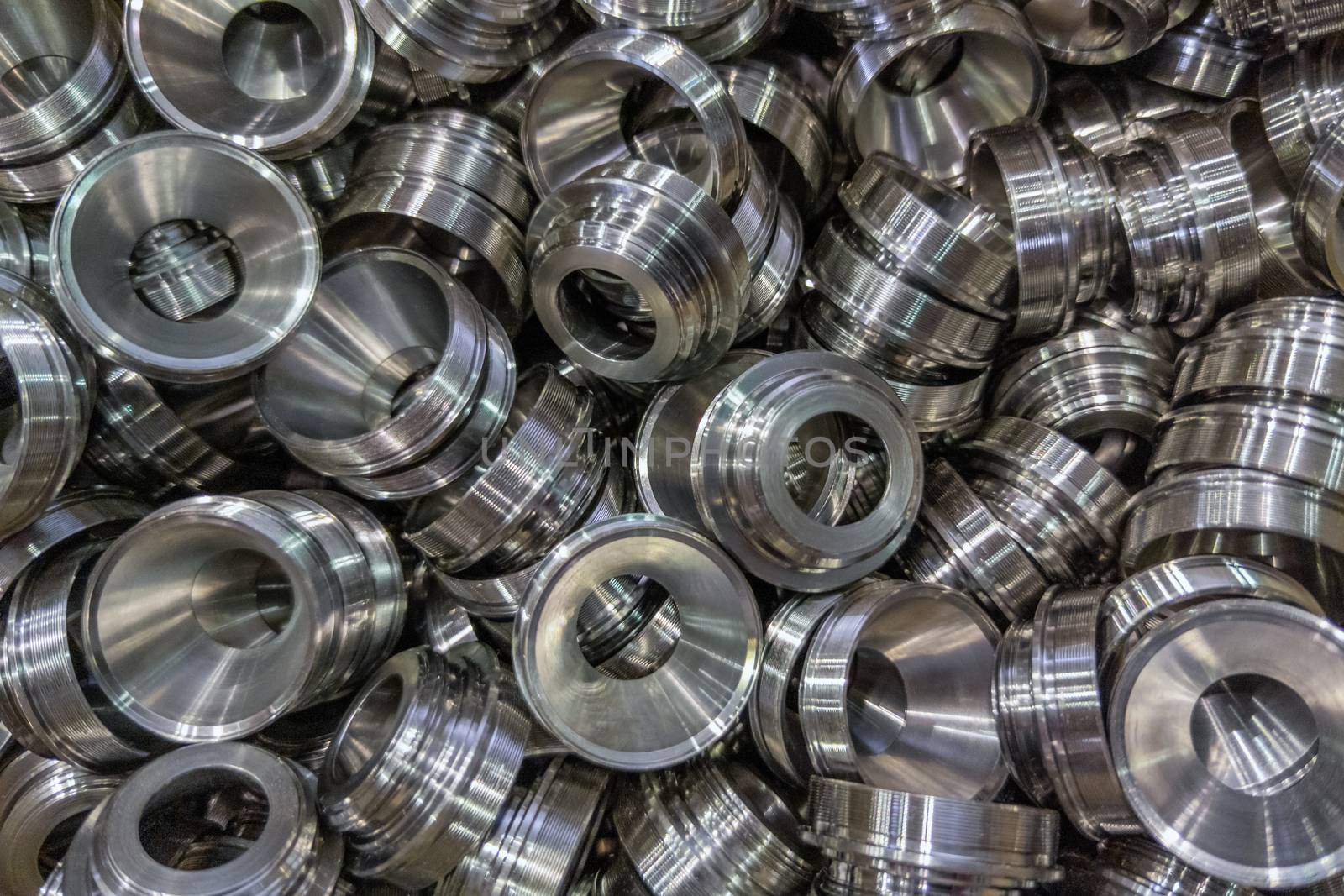 a pile of shiny metal cnc aerospace funnel shape parts production - close-up with selective focus for full frame industrial background