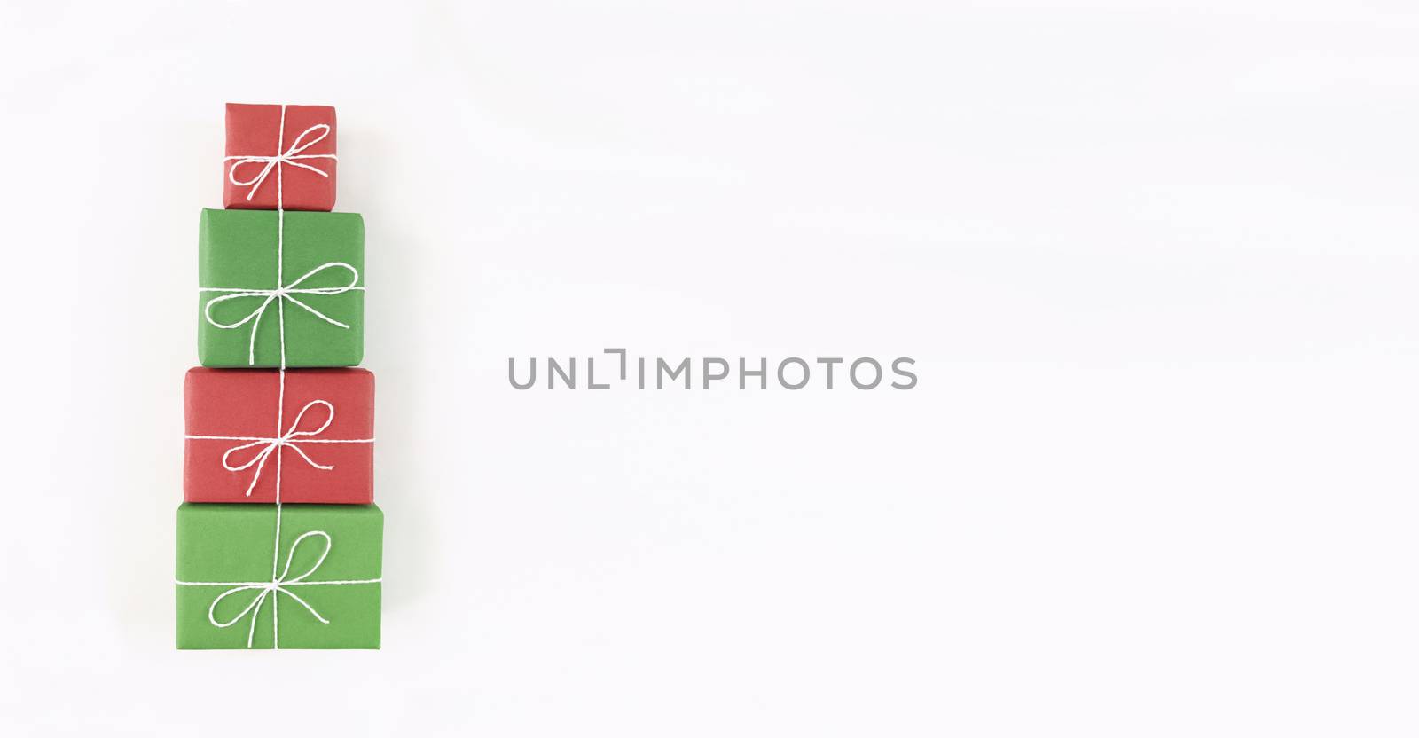 Christmas tree shape from red and green gift boxes on white background. Holiday flat lay with copy space.