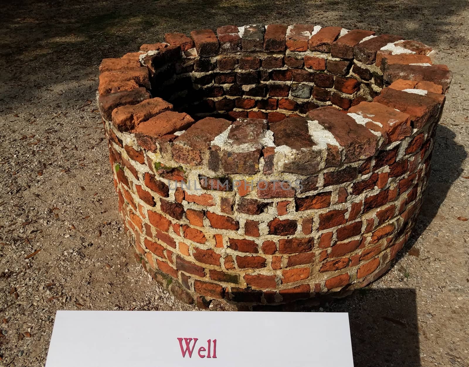 red brick well or masonry with sign or label