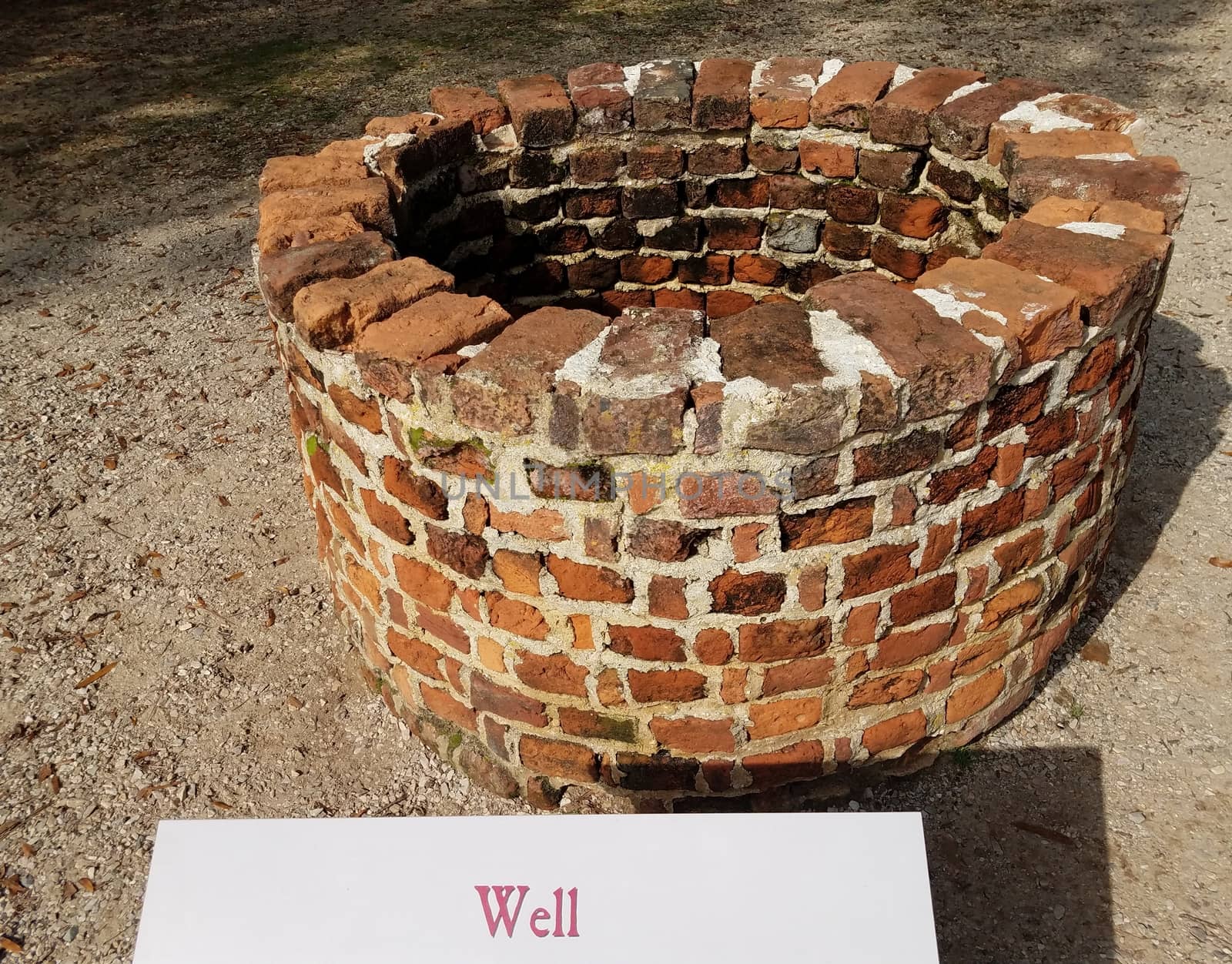 red brick well or masonry with sign or label