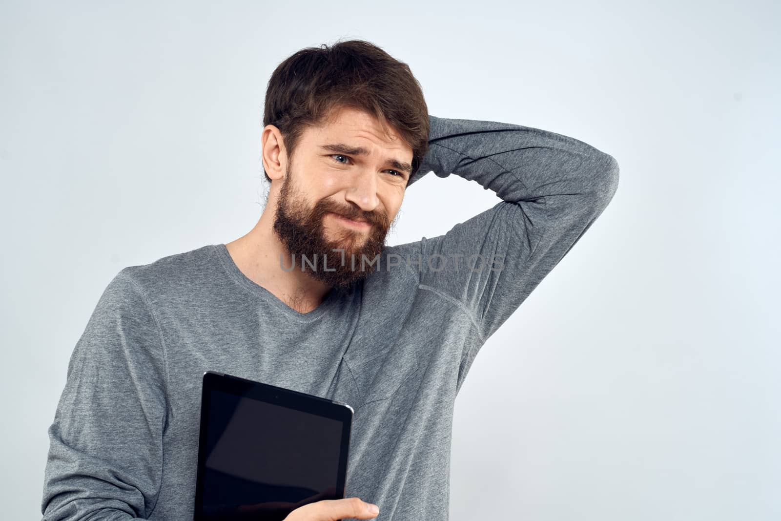 emotional man holding tablet technology communication internet work light background by SHOTPRIME