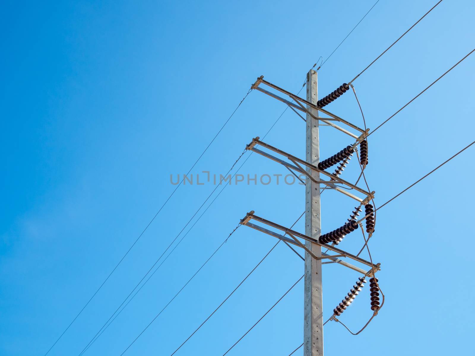 High voltage pole On the background is a bright blue sky.