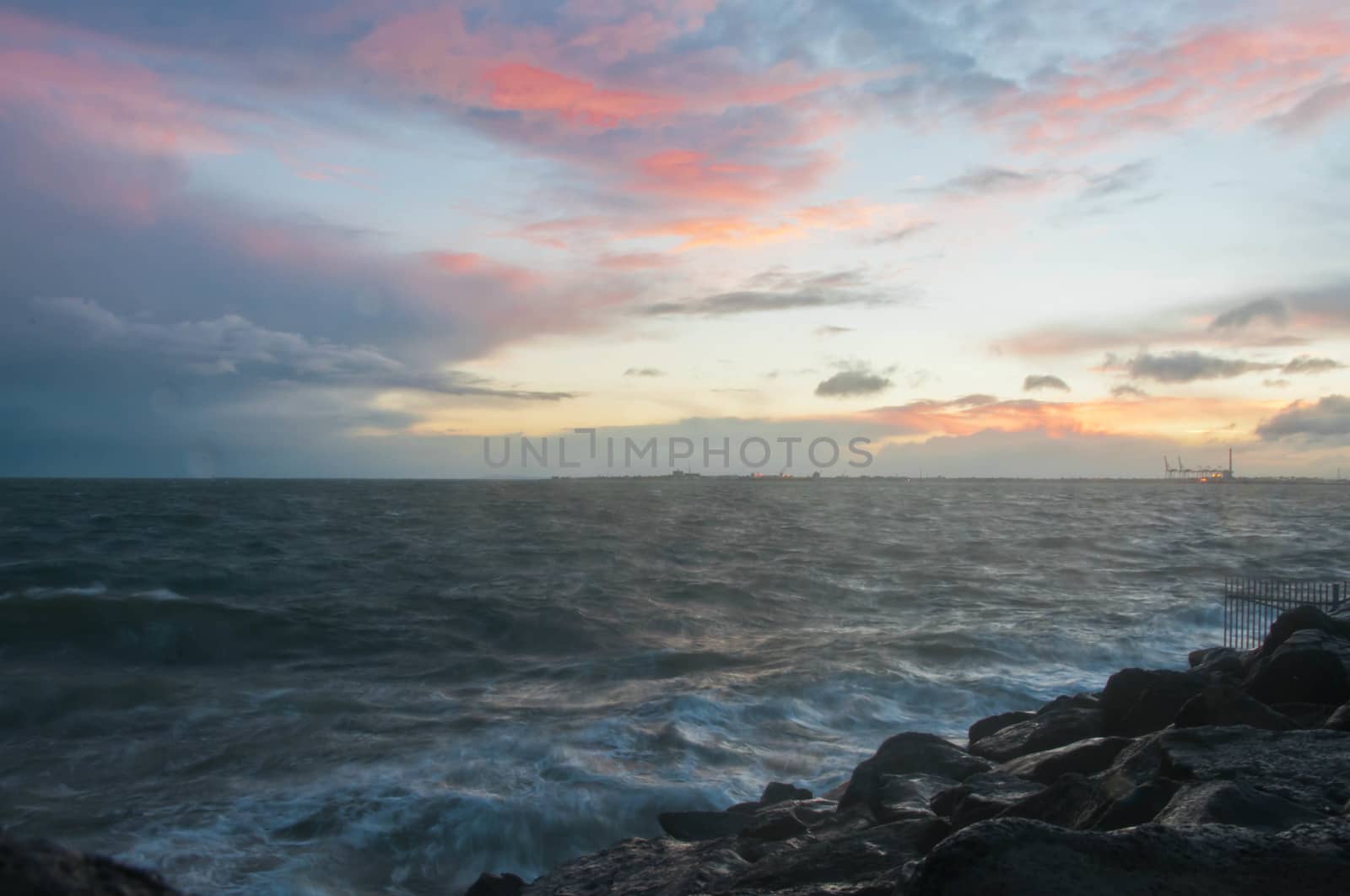 Dramatic splashing ocean wave in the evening with twilight sky in Winter at breakwater at St Kilda pier in Melbourne Australia