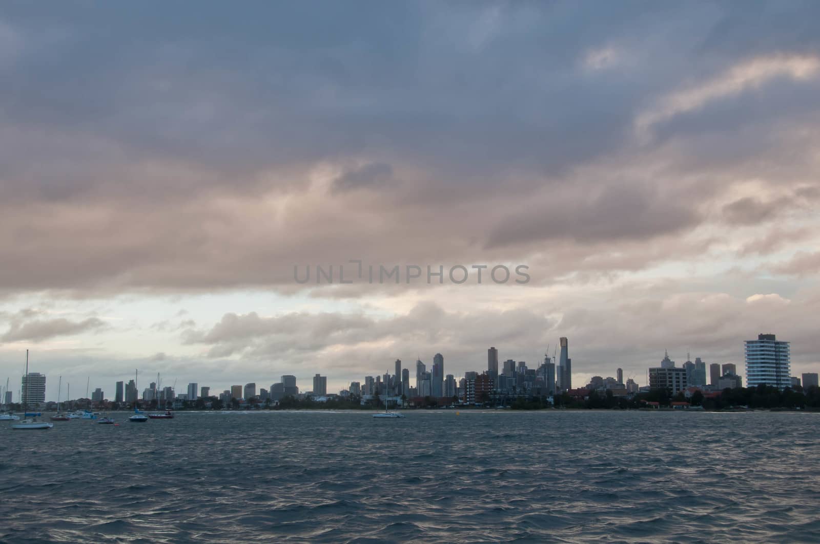 Wide angle evening scene of skyscrapers horizon with ocean and tall office and residential towers in Melbourne Australia