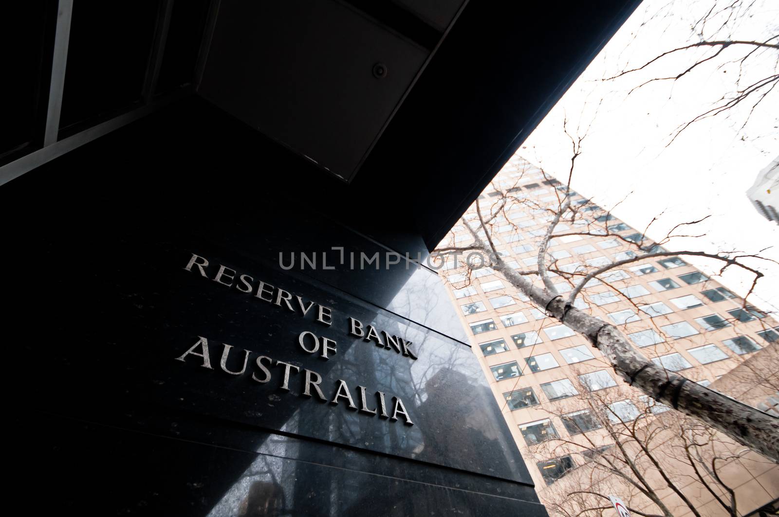 MELBOURNE, AUSTRALIA - JULY 26, 2018: Reserve Bank of Australia name on black granite wall in Melbourne Australia with a reflection of high-rise buildings. The RBA building is located at 60 Collins St, Melbourne VIC 3000 Australia.