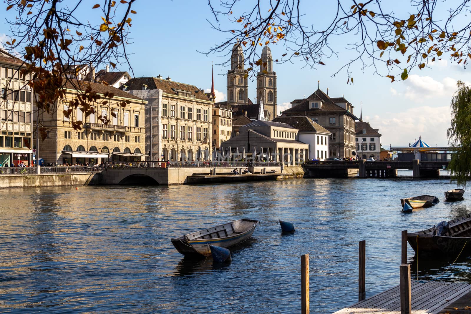 view at the waterfront of Limmat river in Zurich, Switzerland with ships, churchs and other buildings