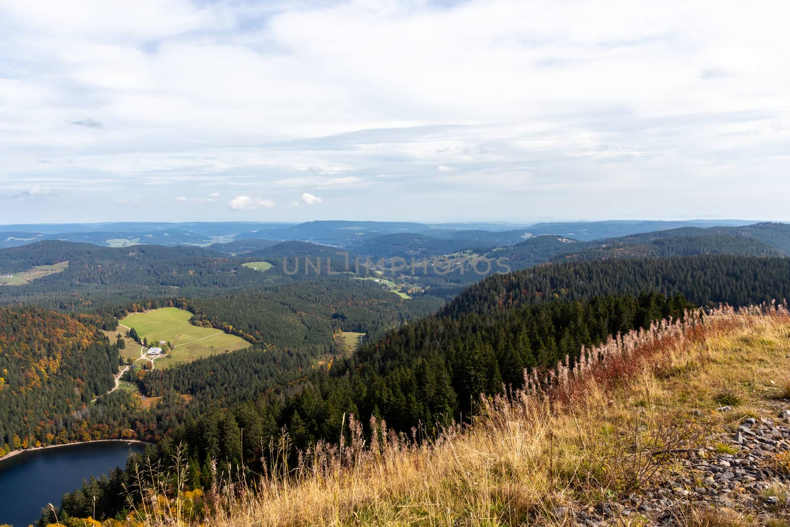 Wide angle view at landscape and lake Feldsee from mountain Feldberg, Black Forest in autumn with multi colored vegetation