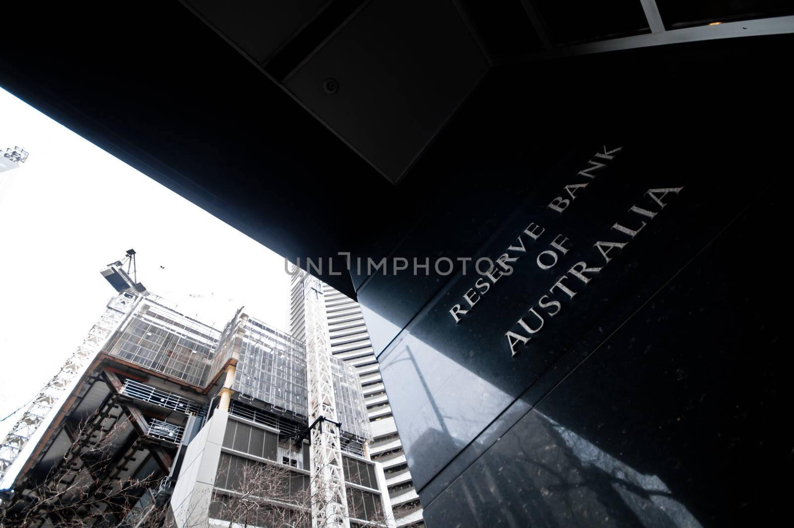 MELBOURNE, AUSTRALIA - JULY 26, 2018: Reserve Bank of Australia name on black granite wall in Melbourne Australia with a reflection of high-rise buildings. The RBA building is located at 60 Collins St, Melbourne VIC 3000 Australia.