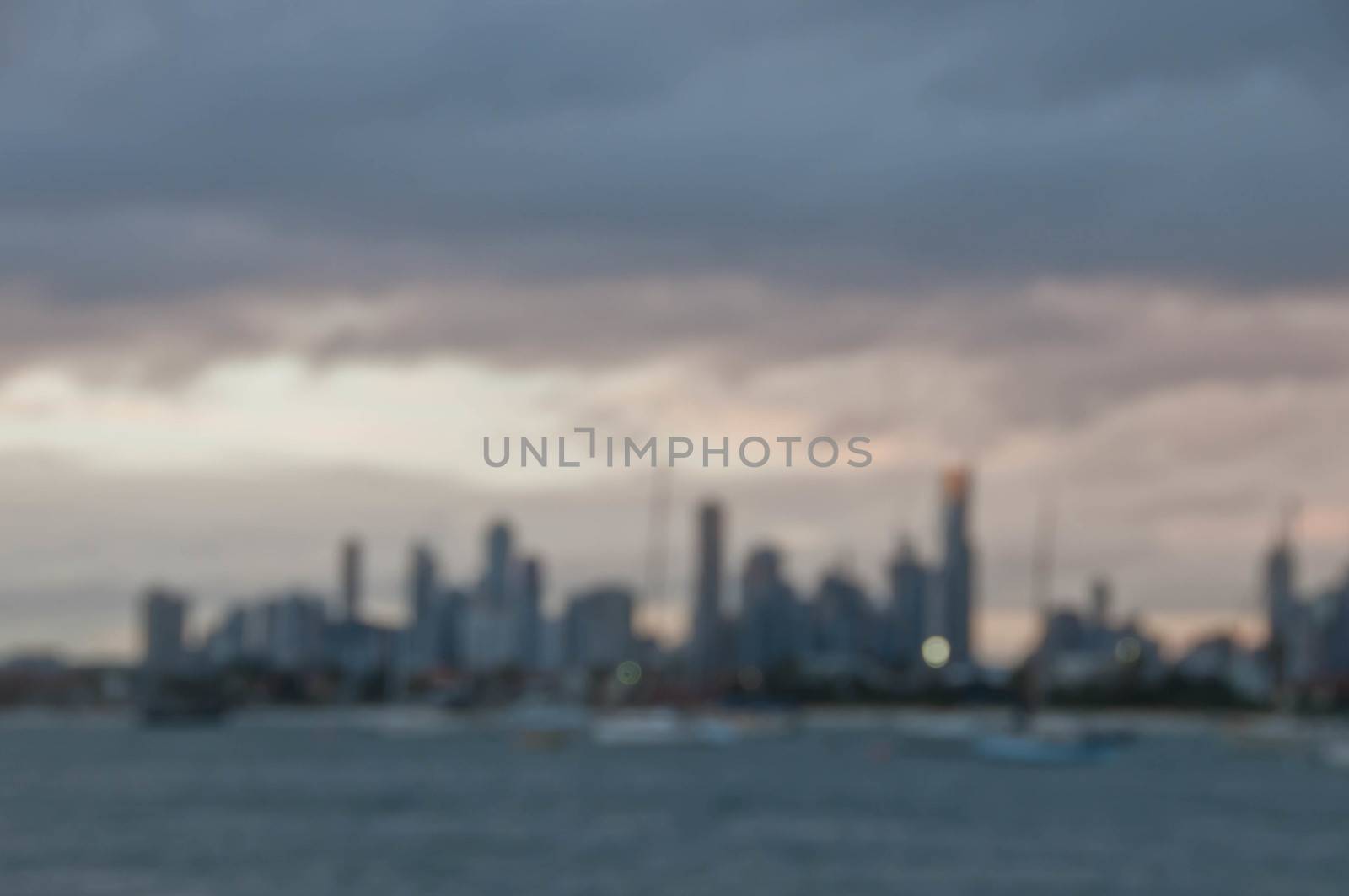 Blurred abstracted evening scene of skyscrapers horizon with ocean and tall office and residential towers in Melbourne Australia