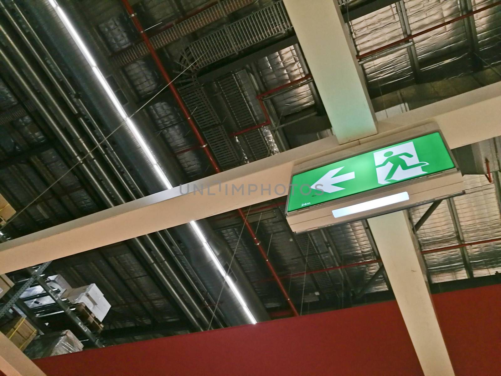 Emergency exit route sign on top of factory warehouse by eyeofpaul