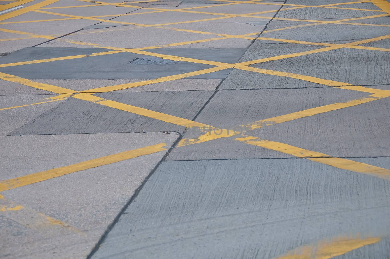 Abstract yellow painted traffic line pattern on concrete road street by eyeofpaul