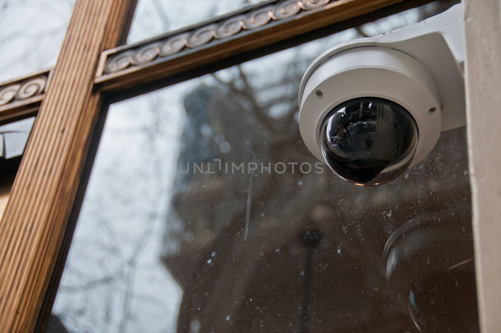 Surveillance CCTV security dome camera near office window by eyeofpaul