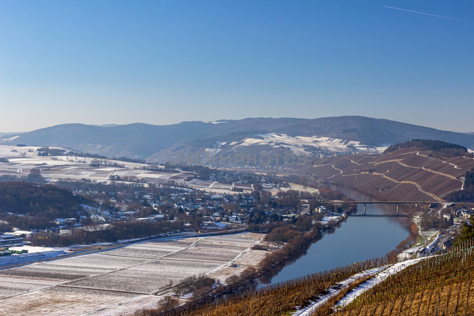 View on the valley of the river Moselle and the wine villages Mülheim and Lieser, Germany in winter with snow