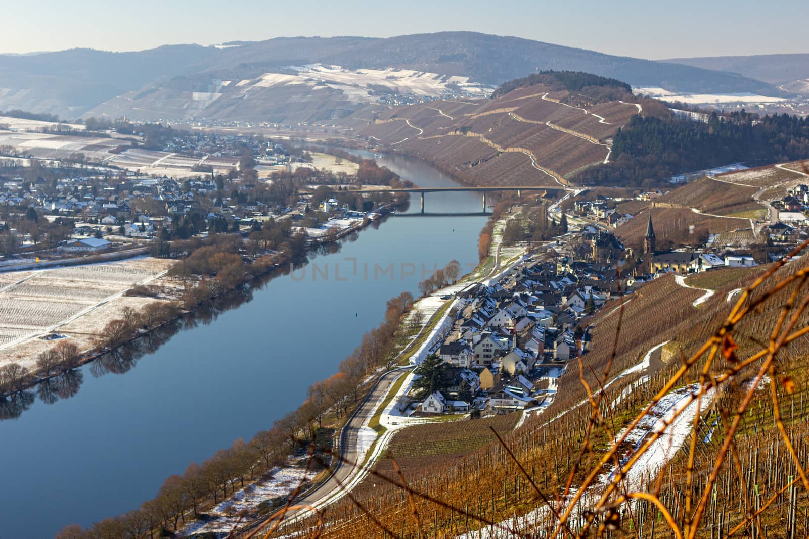 View on the valley of the river Moselle and the wine villages Mülheim and Lieser, Germany in winter with snow