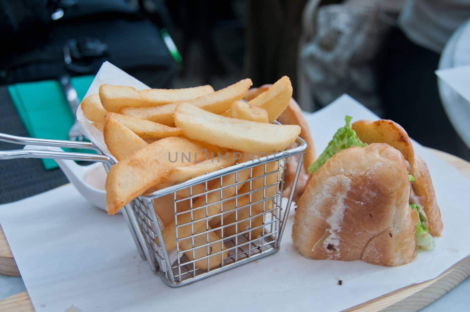 Crispy golden hand cut chips deep fried with French handmade sandwich served on white paper