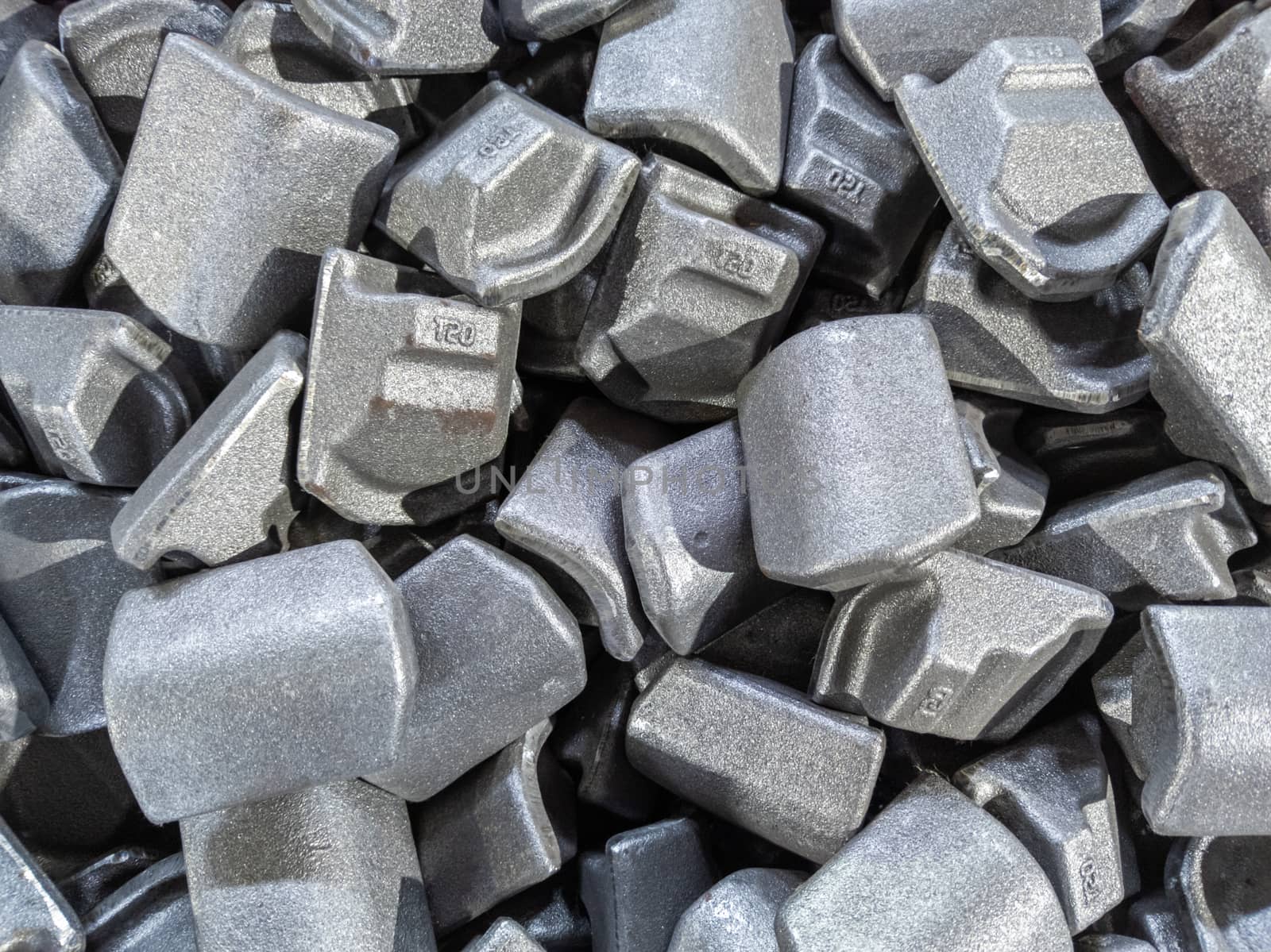heap of gray steel forgings after shot blasting - close-up natural heavy industrial pattern with selective focus and grim mood