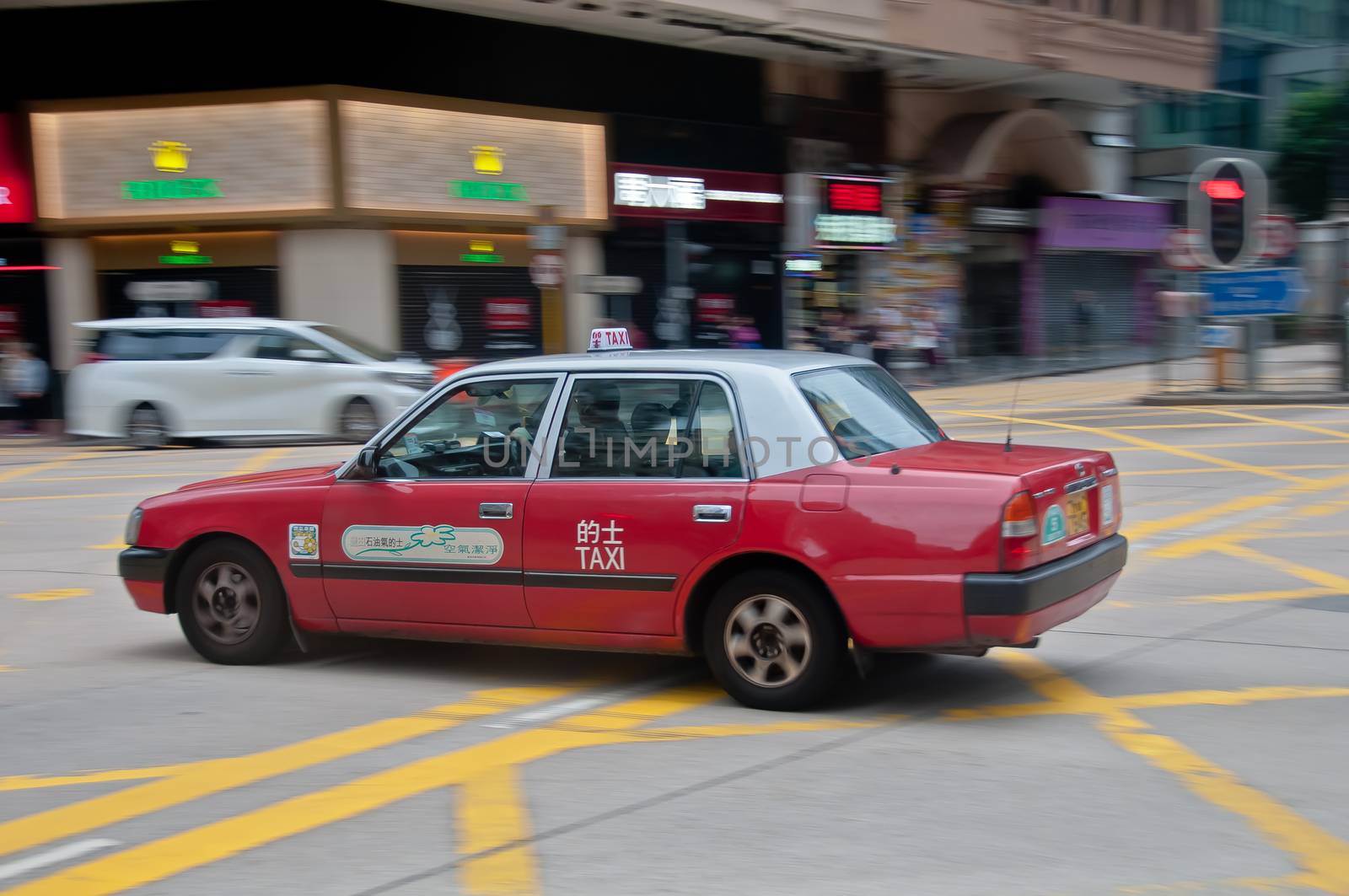 HONG KONG, HONG KONG SAR - NOVEMBER 18, 2018: Fast classic red taxi car in Hong Kong drives fast with motion blur background in city center