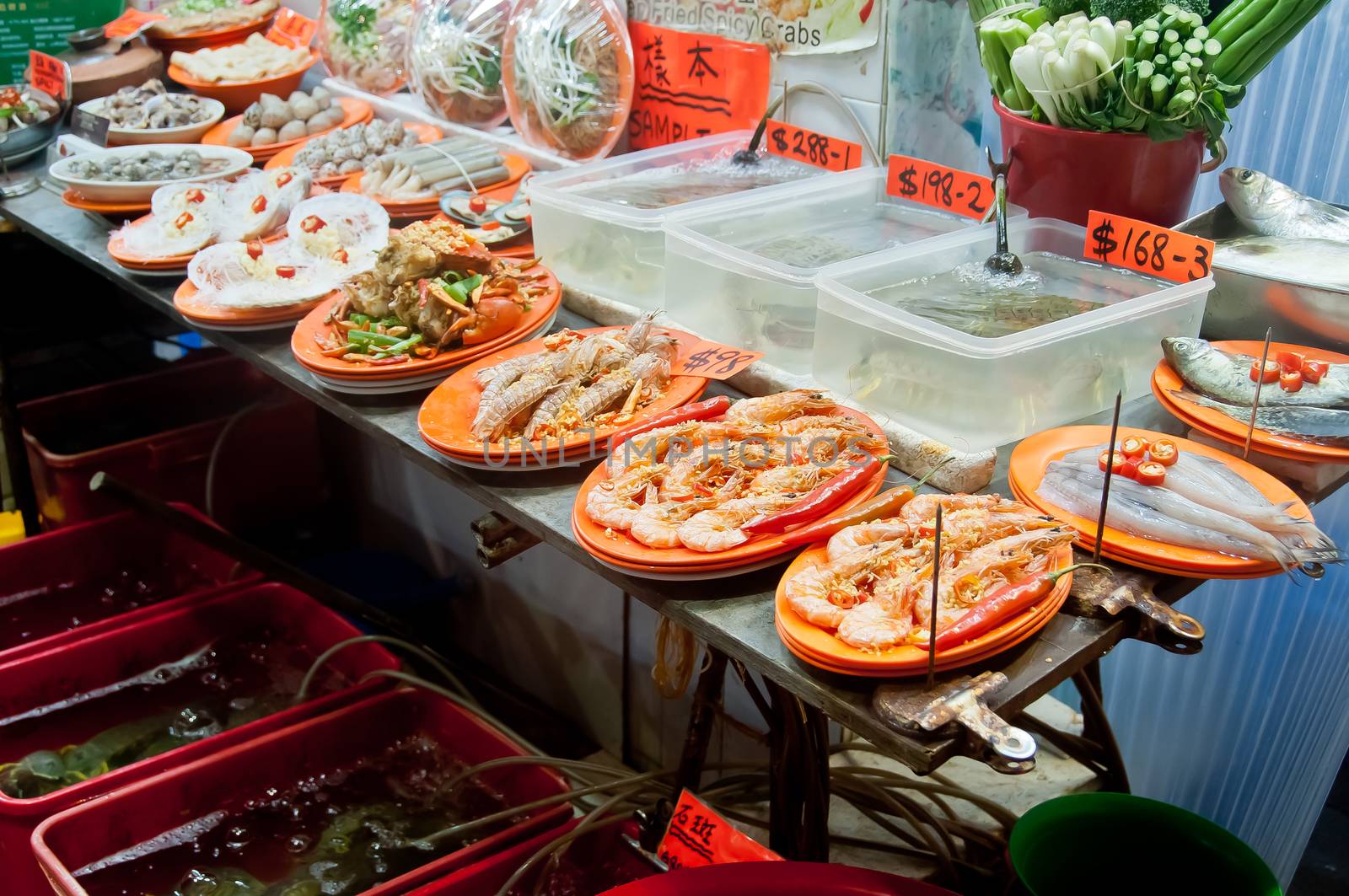 Hong Kong seafood vendor stall street food showing cooked and uncooked fresh seafood near Mong Kok alley