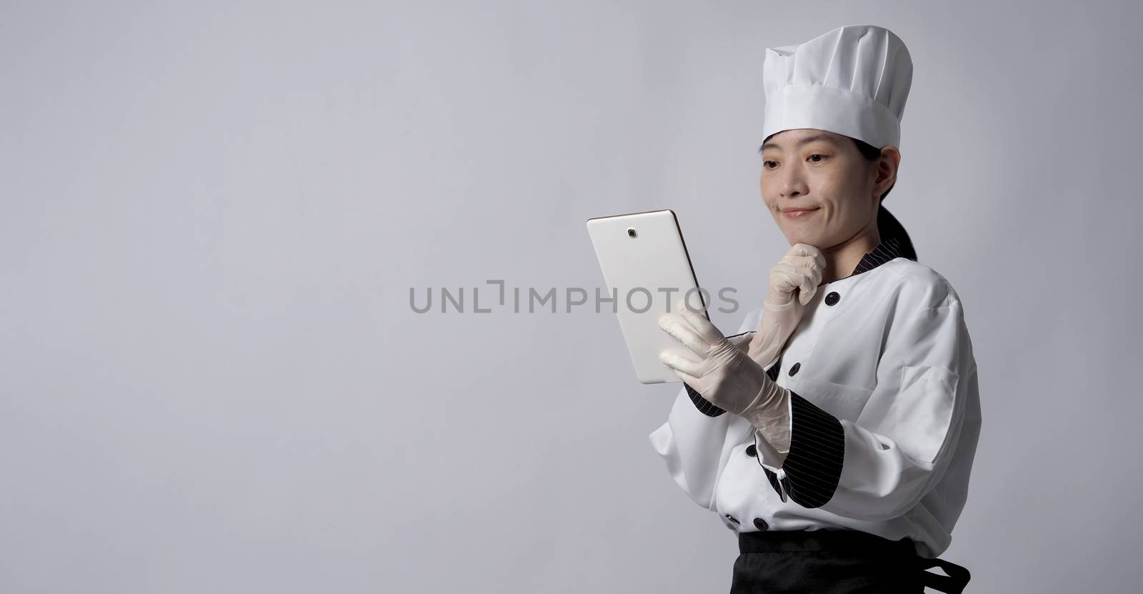 Asian woman chef holding digital tablet and received food order  by gnepphoto