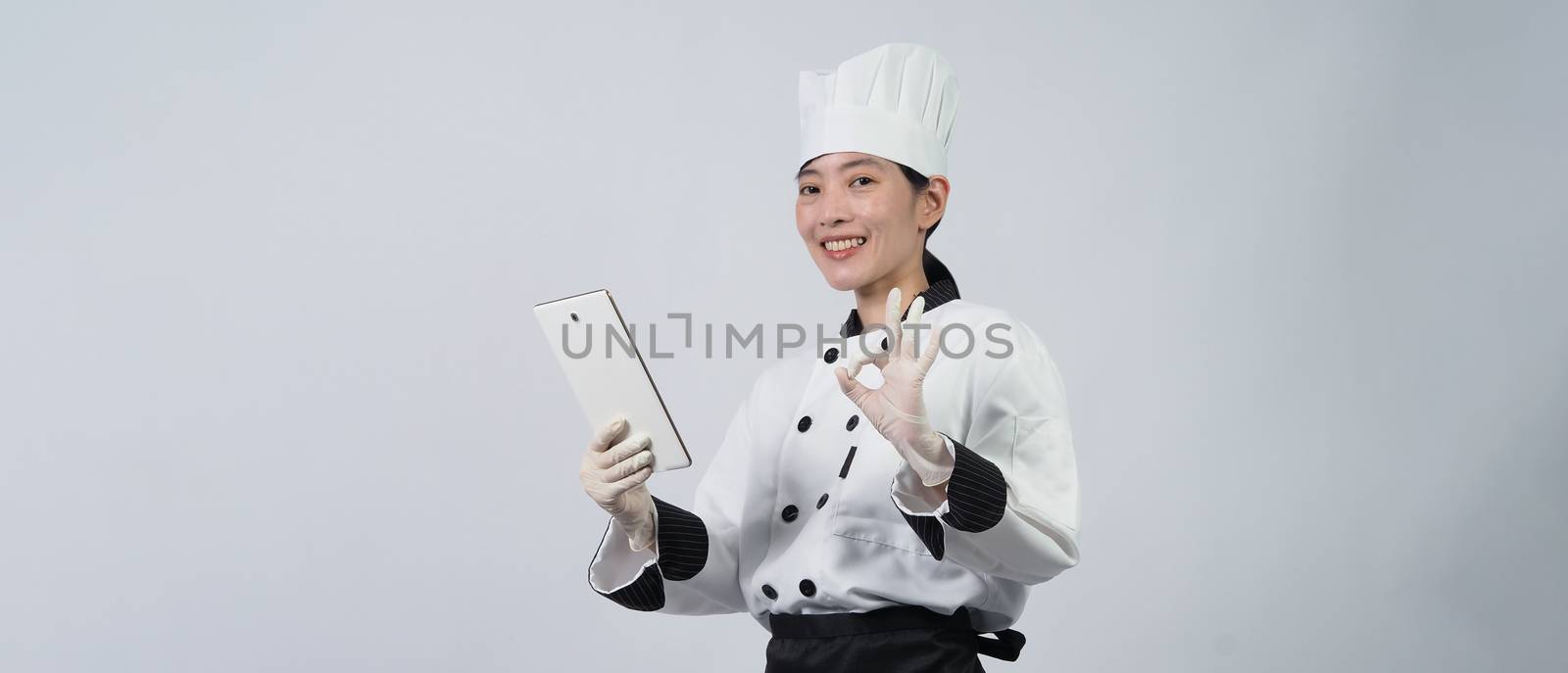 Asian woman chef holding digital tablet and received food order  by gnepphoto