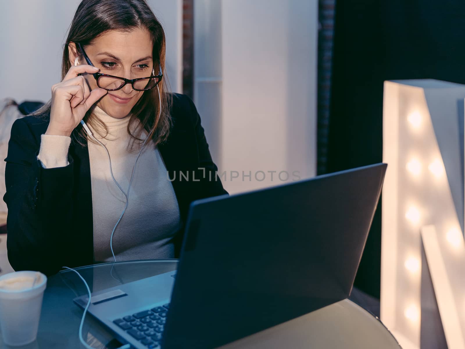 Adult female freelancer using laptop computer for video conference call while sitting in modern coffee shop interior, beautiful Caucasian woman working on net-book during coffee break in cafe bar