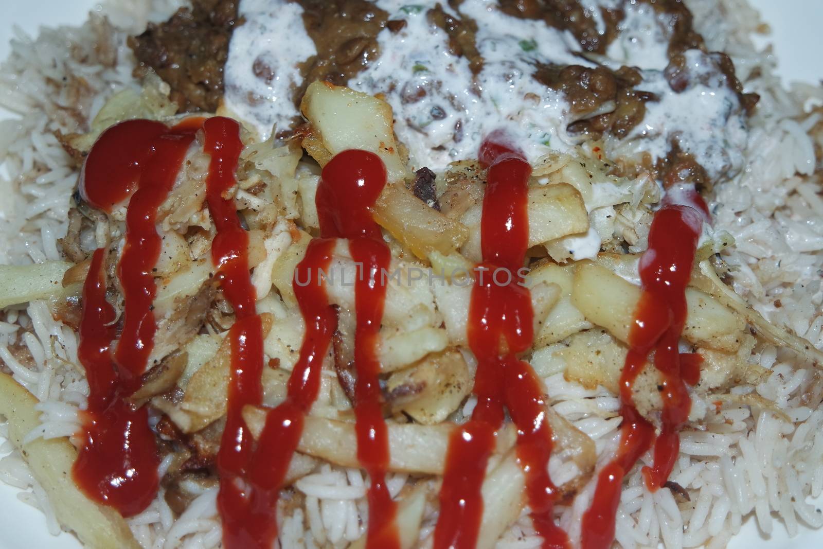 Delicious traditional dish of rice with potato fries and cereals with red ketchup. Food background with copy space for text and advertisements.