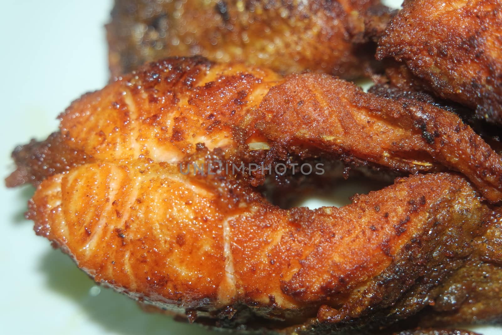 Spicy and crunchy barbecue of fried fish fillet on a white background. Homemade grilled trout fish steaks for health nourishments.
