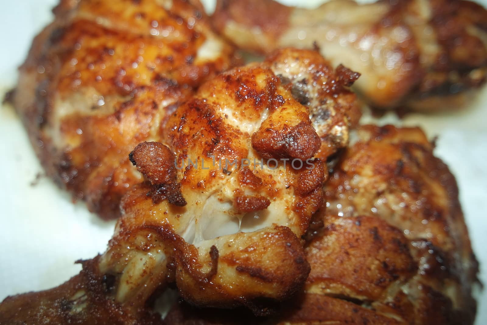 Fried, grilled baked chicken pieces with marinated spices on it by Photochowk