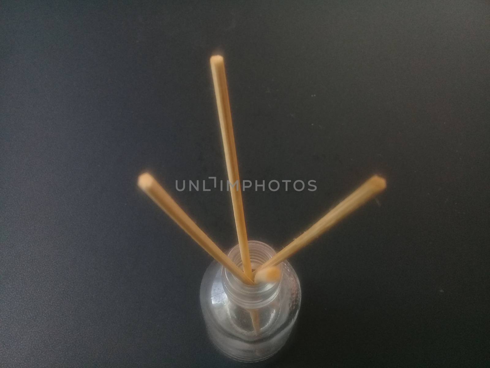 Close-Up Of Incense Sticks In glass Container Against Gray Background. Traditional aroma sticks for fragrance refreshing air