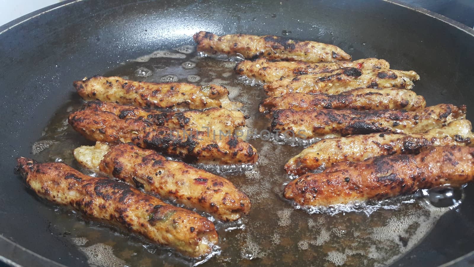 Delicious spicy fried long kebab served in black hot plate by Photochowk