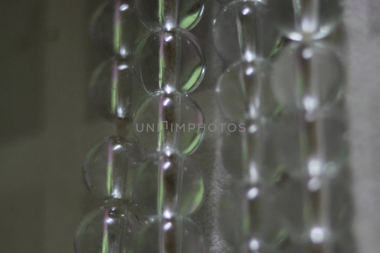 Macro photograph with selective focus of glass shiny prayer beads or rosary with copy space for text. Religion concept of ramadan or Eid for muslims.