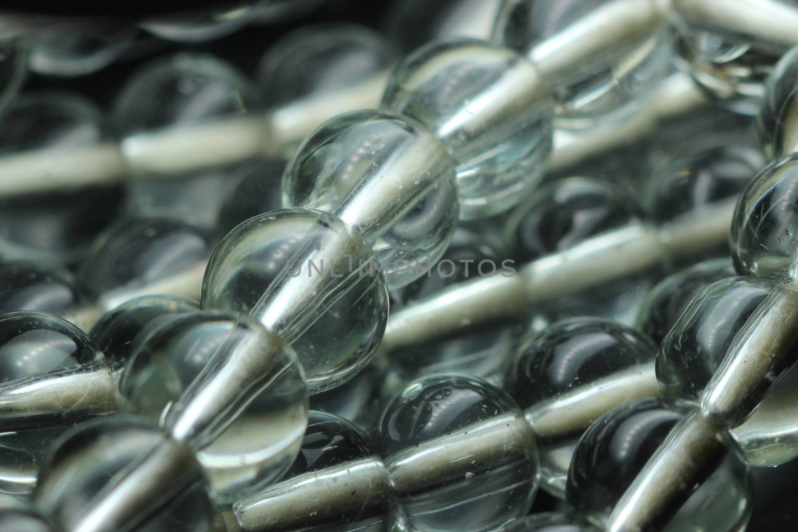 Macro photograph with selective focus of glass shiny prayer beads or rosary with copy space for text. Religion concept of ramadan or Eid for muslims.