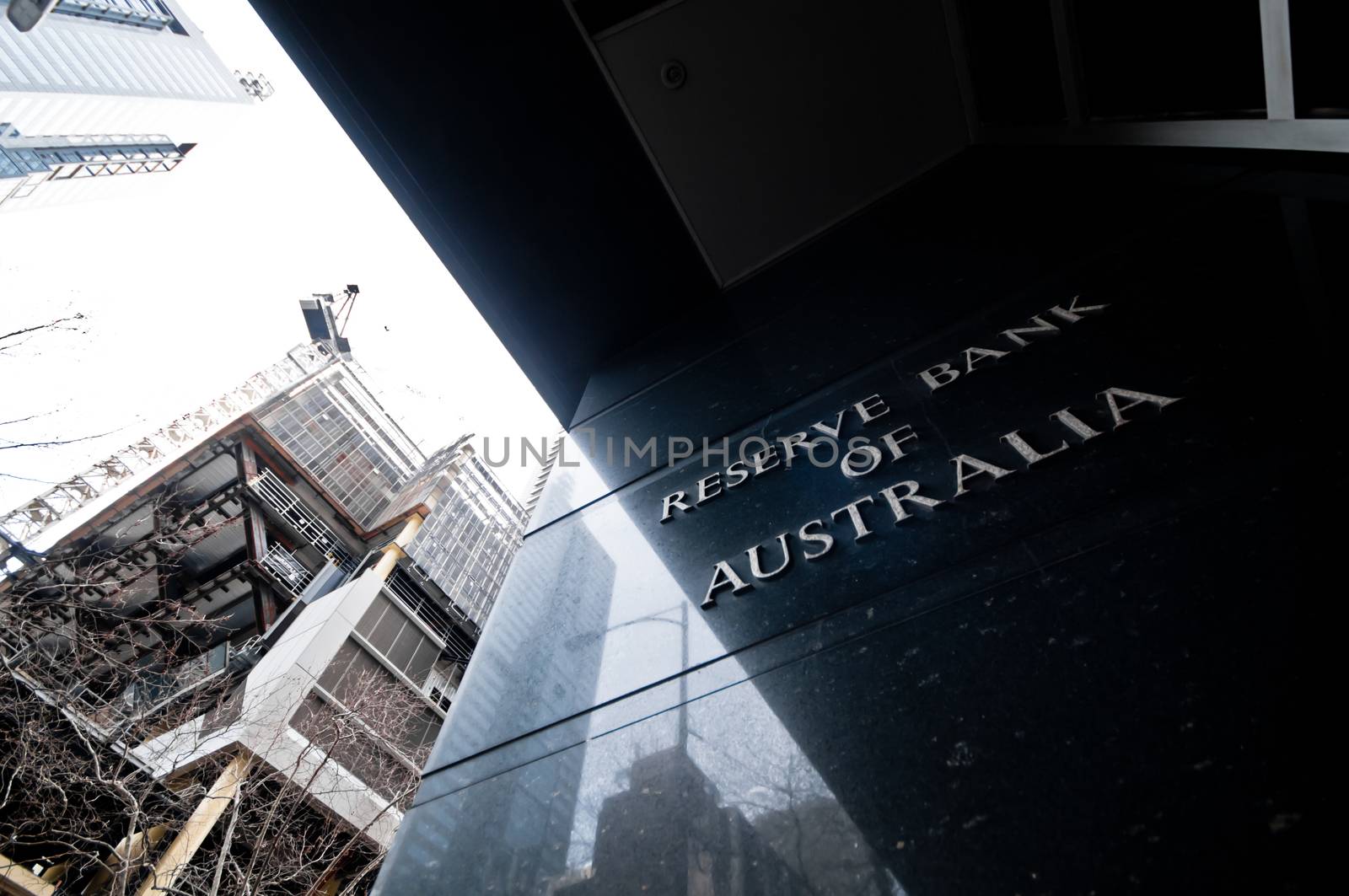 MELBOURNE, AUSTRALIA - JULY 26, 2018: Reserve Bank of Australia name on black granite wall in Melbourne Australia with a reflection of high-rise buildings. The RBA building is located at 60 Collins St, Melbourne VIC 3000 Australia.