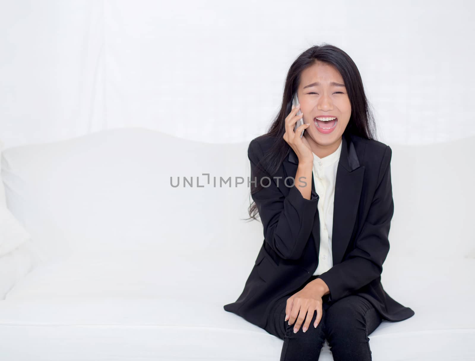 Beautiful young asian woman talking phone and smile in the living room, businesswoman sitting on sofa,businesswoman calling telephone, communication concept.