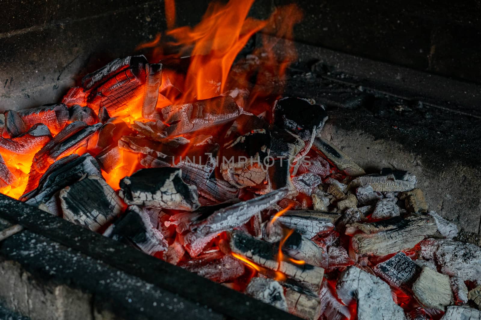 Bright hot coals and a burning fire in the barbecue grill. Red fire and ashes.