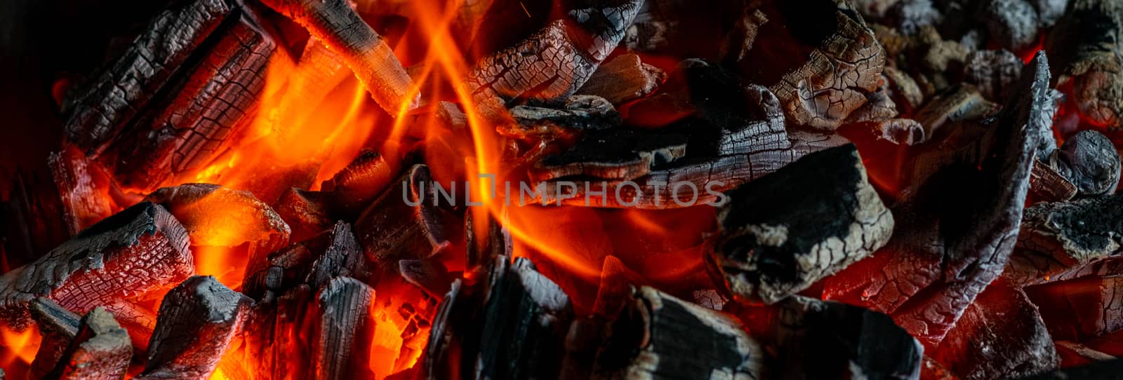 Bright hot coals and a burning fire in the barbecue grill. Red fire and ashes.