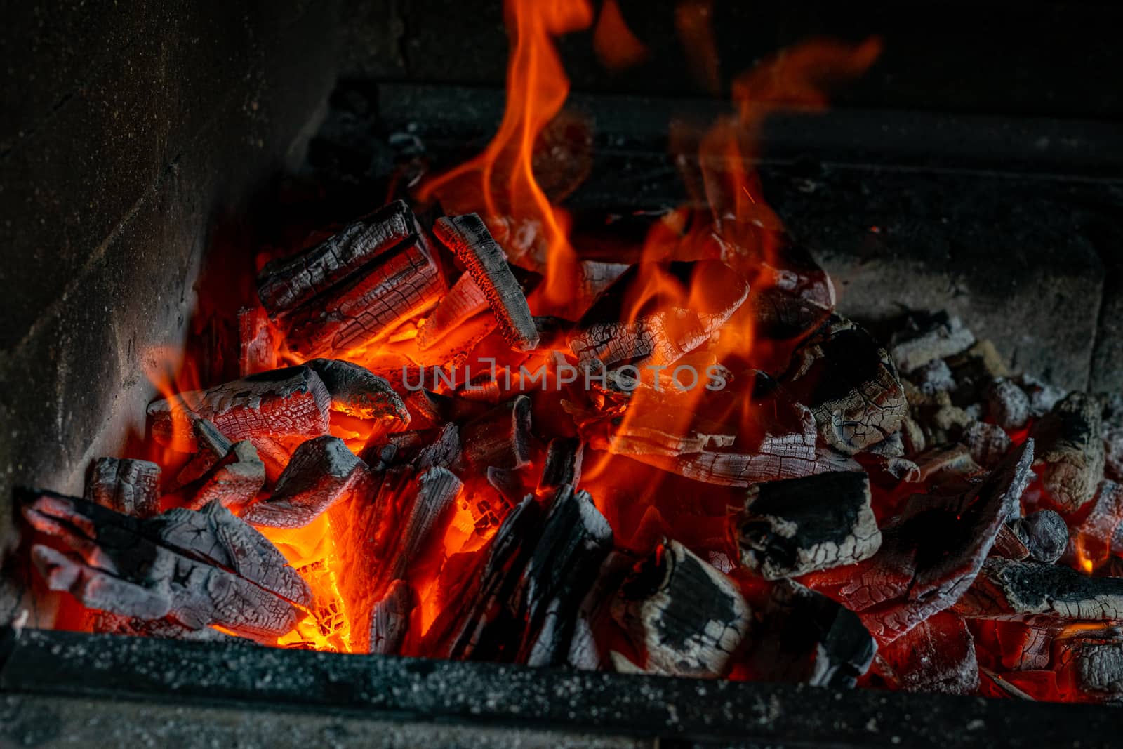 Bright hot coals and a burning fire in the barbecue grill. Red fire and ashes.