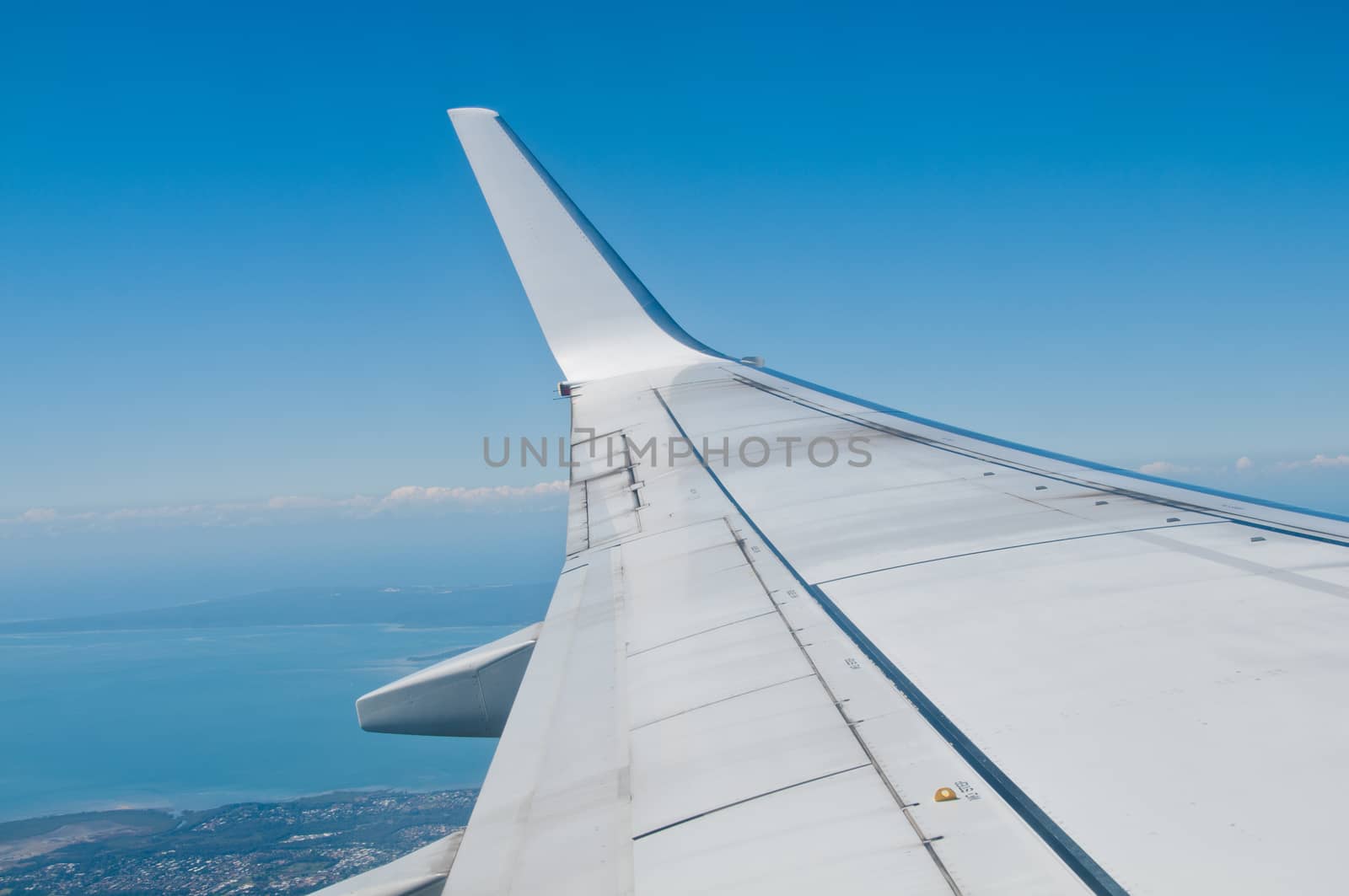 White silver plane wing flying inblue sky by eyeofpaul