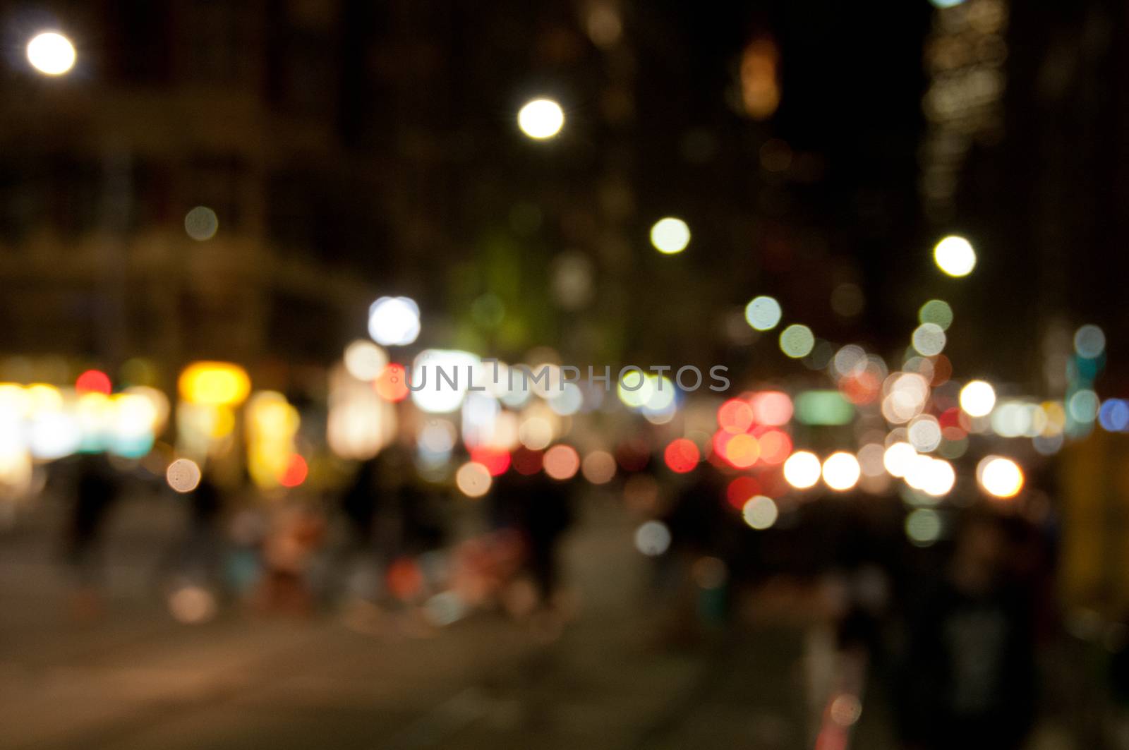 Defocused abstract background of people walking at night in busy city in Winter