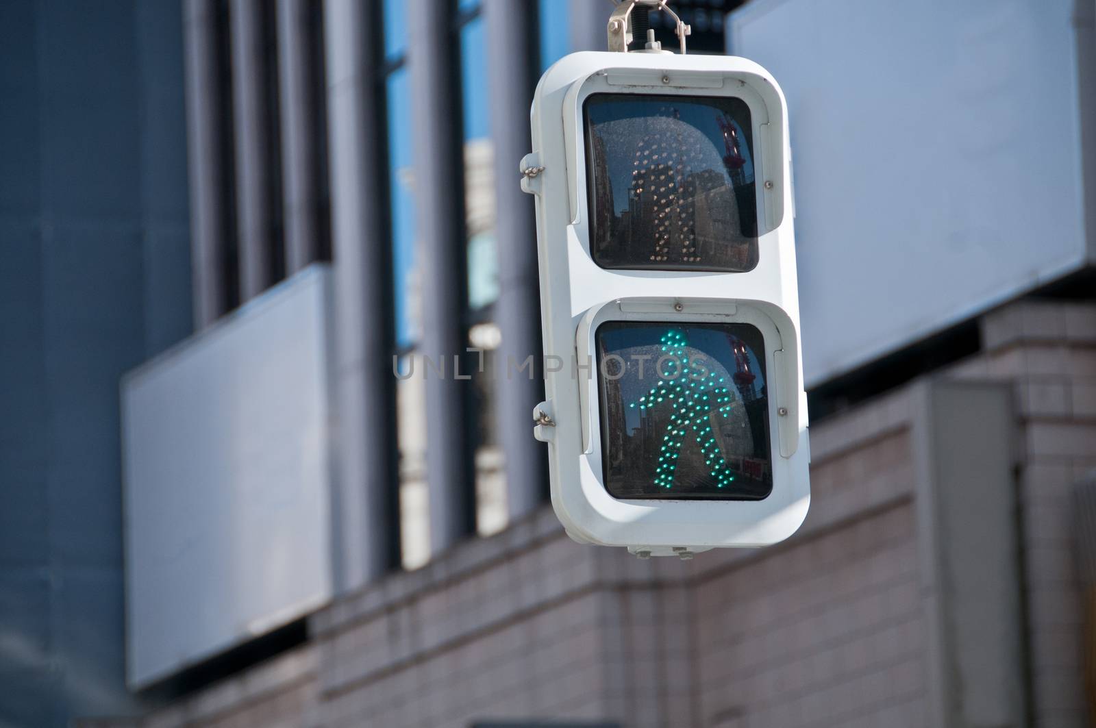 Traffic light sign with green walking man in Japan by eyeofpaul